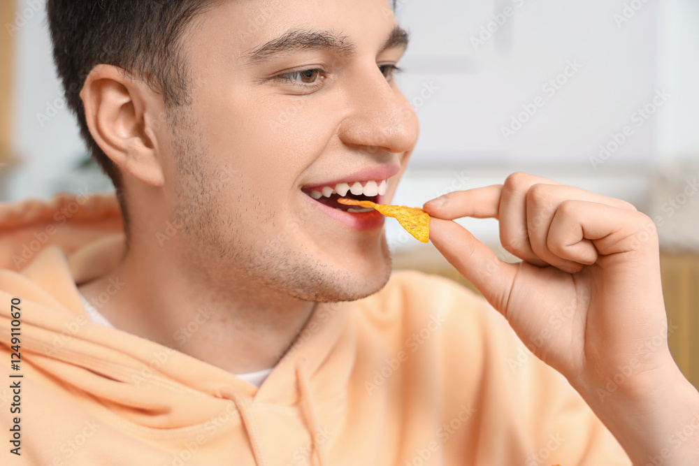 Young man eating tasty nachos at home Young man eating tasty nachos at home