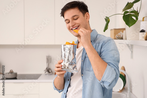 Young man eating tasty nach...