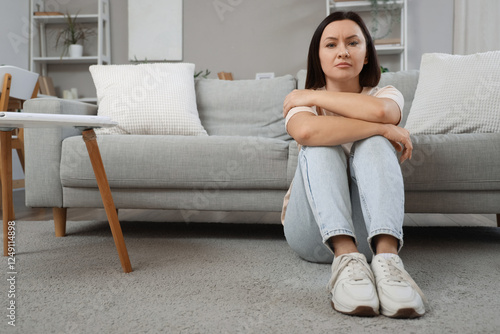 Sad woman sitting on floor ...