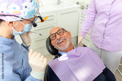 Senior man smiling during dental checkup with dentist and assistant