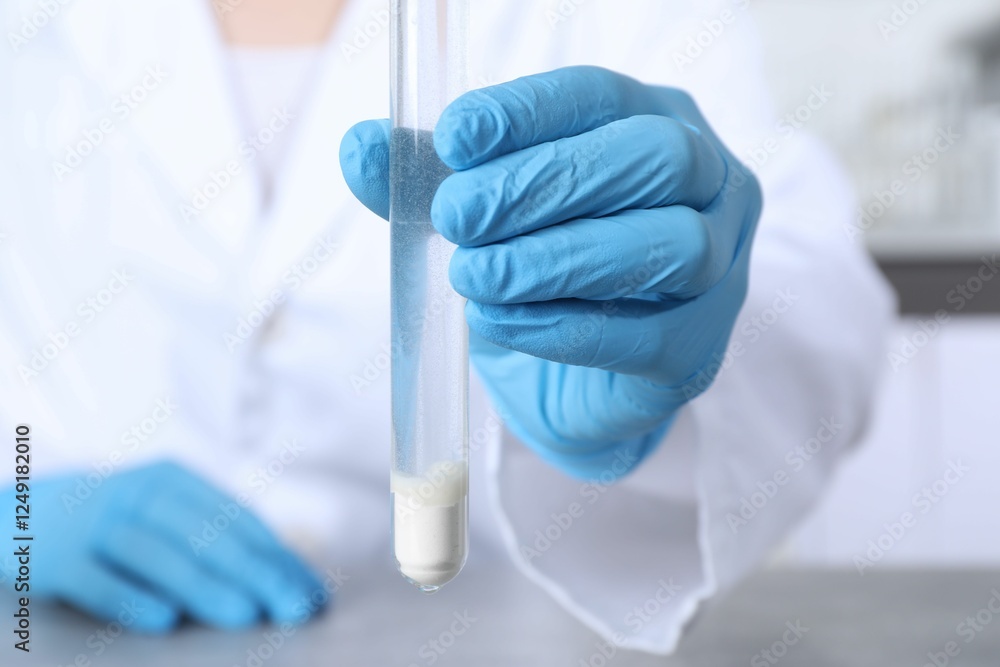 Laboratory testing. Scientist with test tube of sample indoors, closeup Laboratory testing. Scientist with test tube of sample indoors, closeup