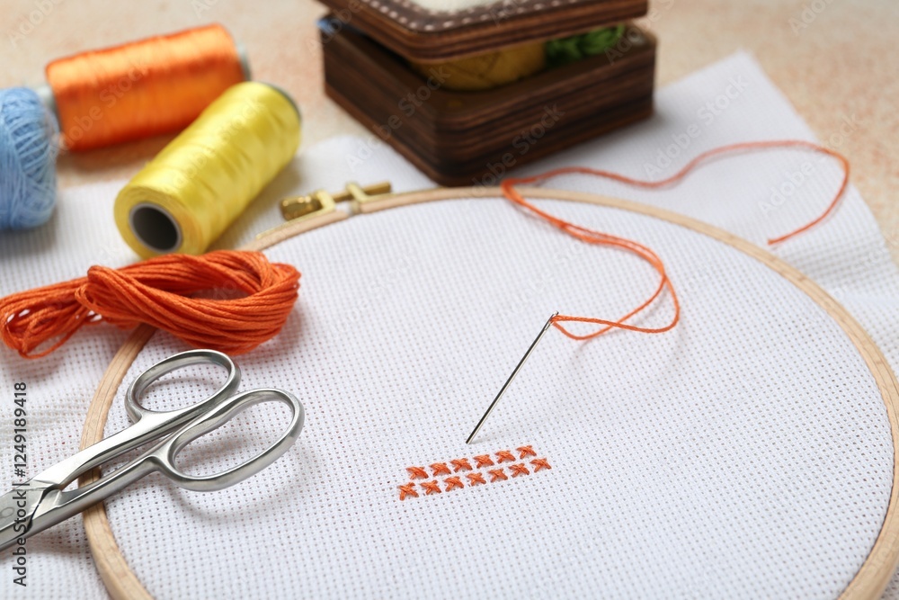 Embroidery and different sewing accessories on table, closeup Embroidery and different sewing accessories on table, closeup