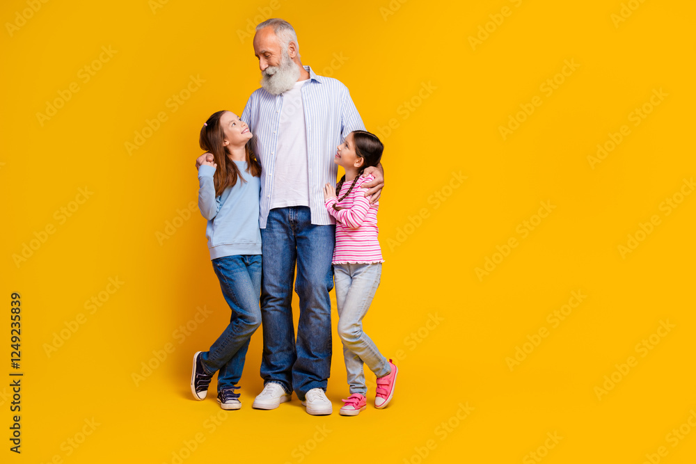 Elderly man enjoying time with his two granddaughters against a vibrant yellow background, depicting family joy and connection Elderly man enjoying time with his two granddaughters against a vibrant yellow background, depicting family joy and connection