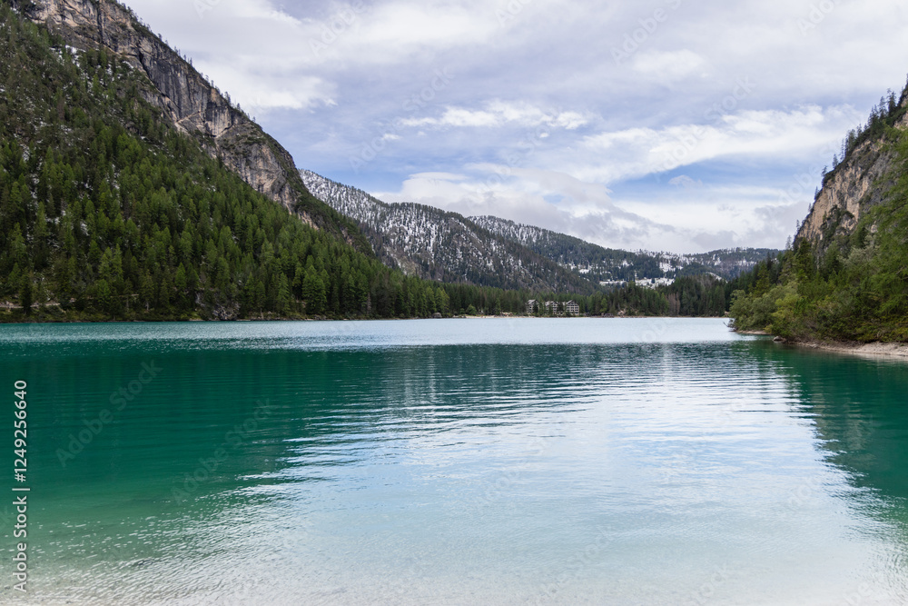 View of Lago di Braies, a stunning alpine lake in Italy with turquoise waters surrounded by dense pine forests and rugged mountain peaks View of Lago di Braies, a stunning alpine lake in Italy with turquoise waters surrounded by dense pine forests and rugged mountain peaks
