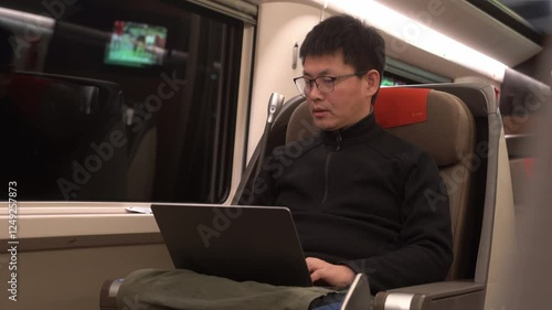 asian man using laptop on train