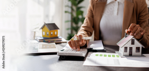 Bild auf Leinwand Business mortgage realtor with house model, sitting at desk, real estate agent manager working on calculator and documents, mortgage and property