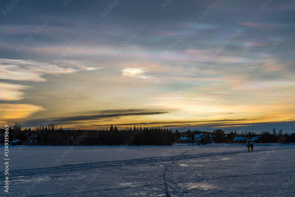Beautiful winter sunset with rare nacreous clouds known as rainbow clouds over frozen lake Akaslompolo in Finnish Lapland. Beautiful winter sunset with rare nacreous clouds known as rainbow clouds over frozen lake Akaslompolo in Finnish Lapland.