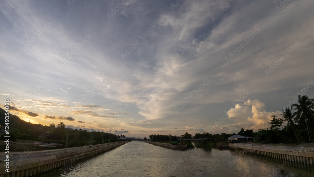 Sunset at the river in the countryside of Indonesia with cloudy sky. Sunset at the river in the countryside of Indonesia with cloudy sky.