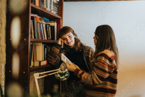 Photos Young friends conversing and enjoying a cozy moment in a warmly lit library