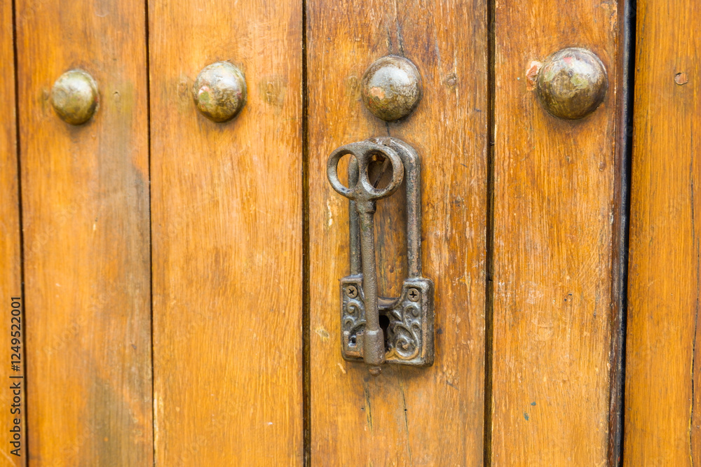 Close up of old Key in wooden door at home, Brown Wood Front Door with Ornate Brass Skeleton Key,copy space.. Close up of old Key in wooden door at home, Brown Wood Front Door with Ornate Brass Skeleton Key,copy space..