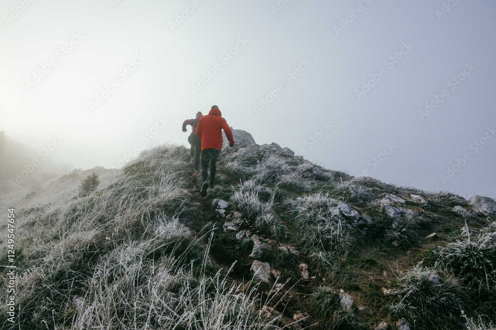 Fototapeta premium Trail running couple man and woman running on a mountain path