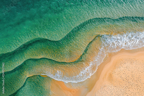 Aerial View of Ocean Waves Meeting Sandy Shoreline in Vivid Blue-Green Colors