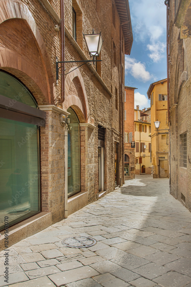 Obraz premium Old street in the historical center of Siena, the UNESCO World Heritage Centre unchanged for 13-14 centuries, with its medieval streets looked like in the early Middle Ages. Italy, 2019