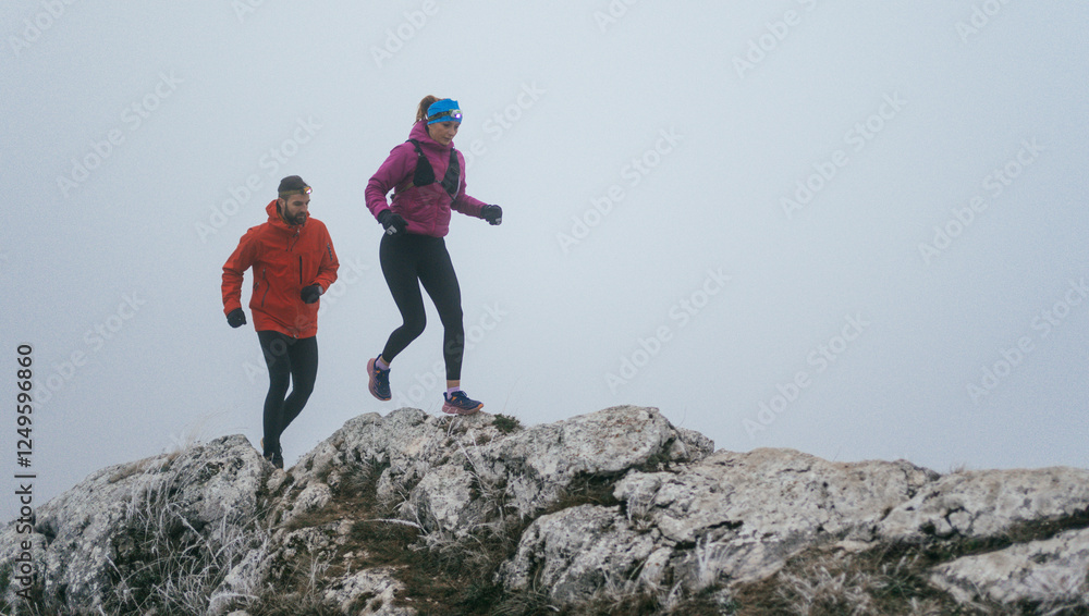 Fototapeta premium Trail running couple man and woman running on a mountain path