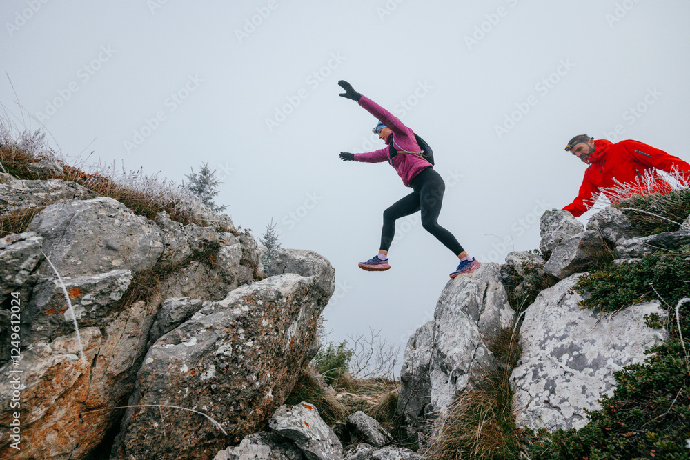 Fototapeta premium Trail running couple man and woman running on a mountain path
