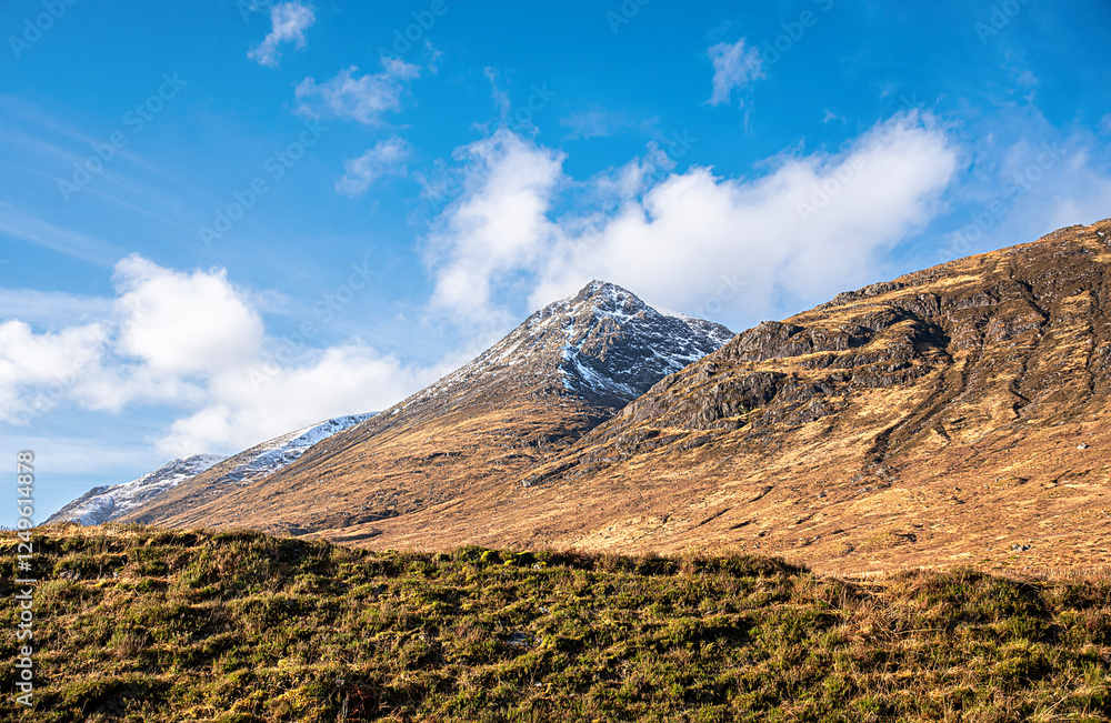 Obraz premium Landscape photography of mountain Beinn Fhionnlaidh, Glencoe, Scotland, UK, winter, snow on the mountain peak, hiking, valley, viewpoint, scenic, rocky hill, blue sky with clouds, travel