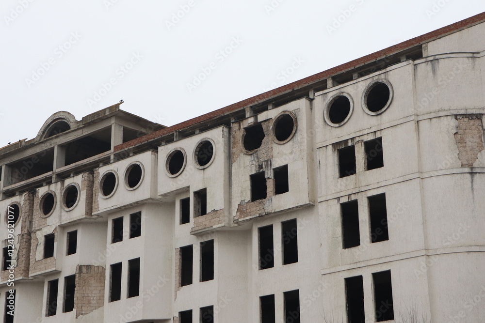 Fototapeta premium An Abandoned Building Featuring a Distressed Facade Accompanied by Unique Circular Windows