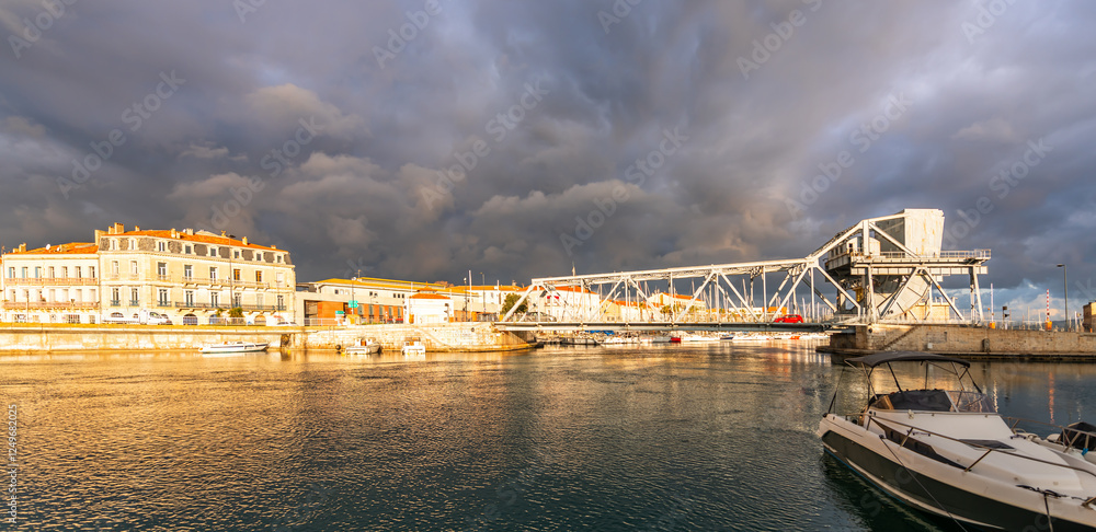 Fototapeta premium Bridge of the Tivoli and boats on the Peyrade canal, from the orient quay in Ste, Occitanie, France