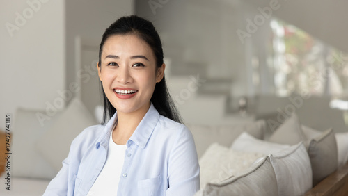 Free Download Happy beautiful young Vietnamese woman posing for portrait at home, sitting on sofa, looking at camera with toothy smile, laughing. Positive cheerful Asian female model banner head shot - GFXLoad