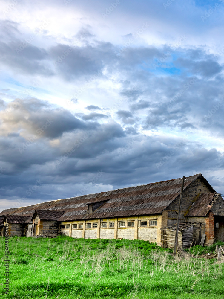 Large, old building with a lot of windows sits in a field Large, old building with a lot of windows sits in a field