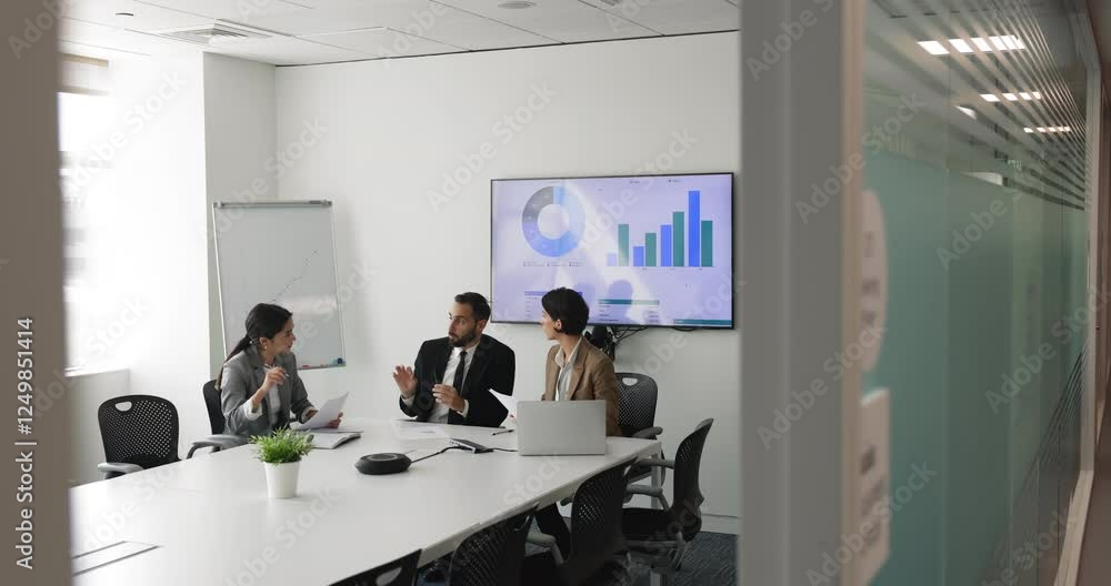 Multi-ethnic staff take part in group briefing seated at table in modern conference room engaged in teamwork and collaboration, discussing sales data, forecasting, reviewing reports, analyzing data Multi-ethnic staff take part in group briefing seated at table in modern conference room engaged in teamwork and collaboration, discussing sales data, forecasting, reviewing reports, analyzing data