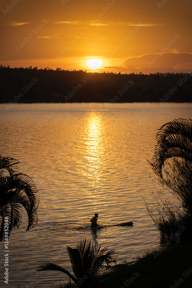Man Floating on a Tree Log in Rwanda