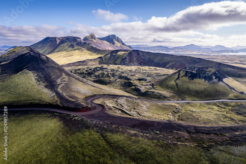 Stunning aerial image showcasing a volcanic crater surrounded Landmannalaugar mountains and by hills and expansive wilderness, emphasizing the raw beauty and geology of volcanic regions in Iceland
