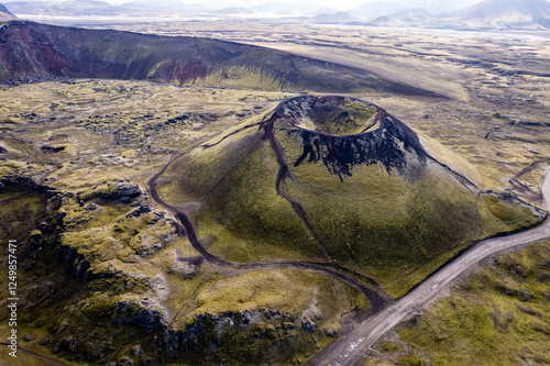 Stunning aerial image showcasing a volcanic crater surrounded Landmannalaugar mountains and by hills and expansive wilderness, emphasizing the raw beauty and geology of volcanic regions in Iceland