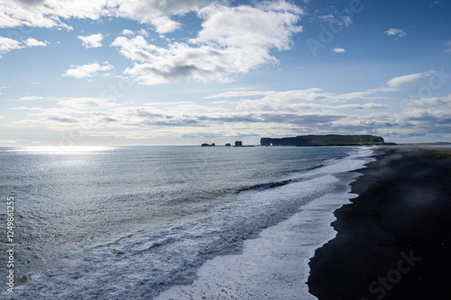 Aerail view a stunning black sandy beach Reynisfjara , sunset in Iceland VIK Myrdal in Golden Circle area with Atlantic Ocean waves crashing and volcanic rock formations photo