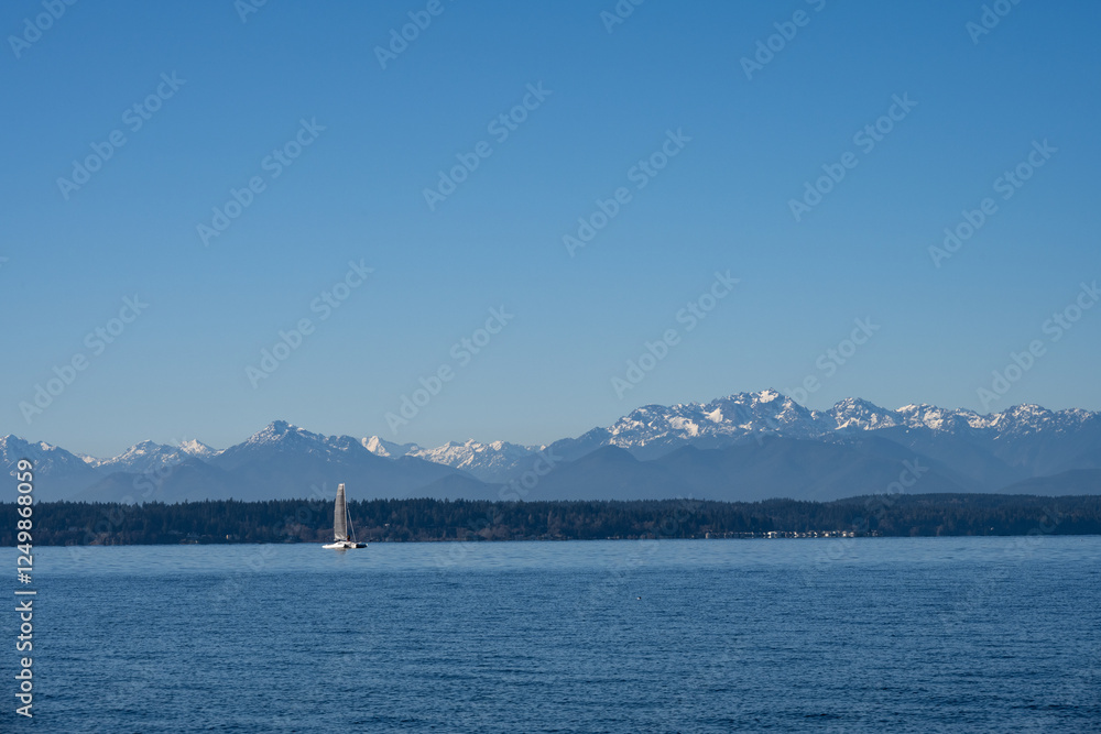 Cool blue winter landscape looking across Puget Sound with the Olympic Mountains in the background, sunny winter day with catamaran sailing on the Salish Sea
Cool blue winter landscape looking across Puget Sound with the Olympic Mountains in the background, sunny winter day with catamaran sailing on the Salish Sea