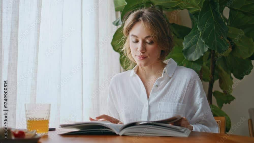 Lady enjoy fashion magazine at apartment table closeup. Woman flipping pages Lady enjoy fashion magazine at apartment table closeup. Woman flipping pages