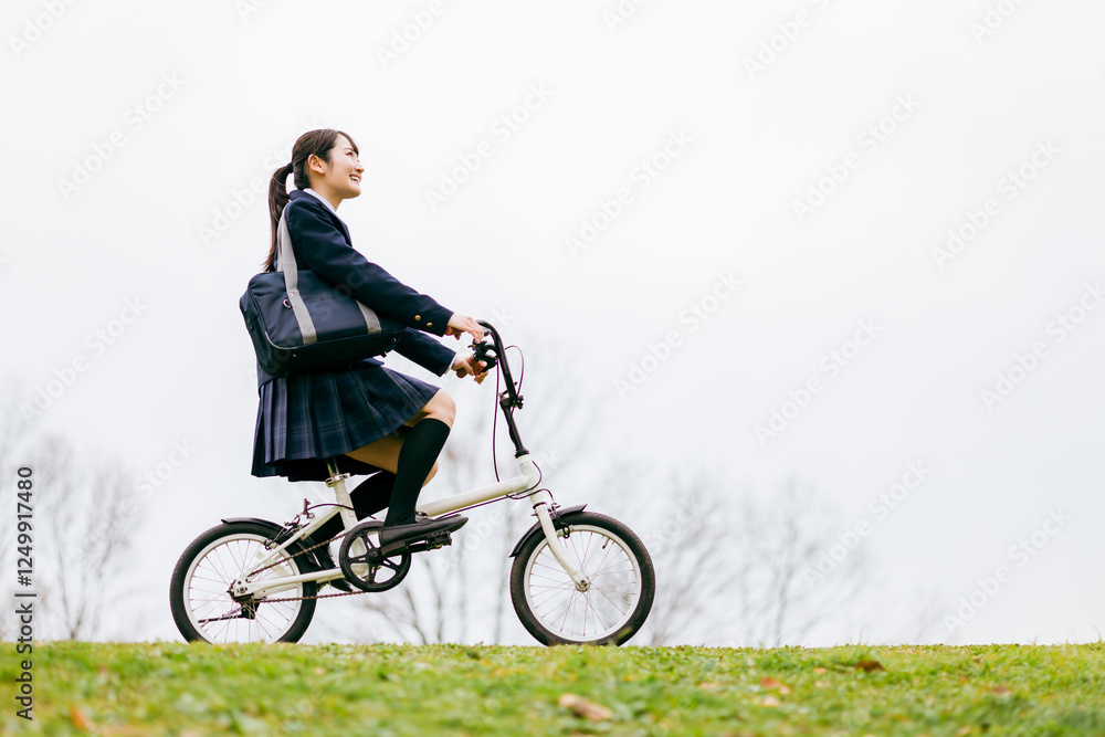 Fototapeta premium 自転車通学する制服姿の中学生・高校生の女の子 