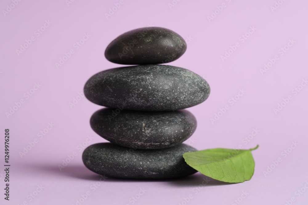 Fototapeta premium Stack of rocks on lilac background. Harmony and life balance