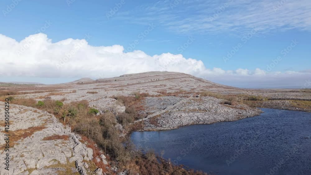 Rocky limestone landscape with a lake in The Burren, Ireland, under a bright sky Rocky limestone landscape with a lake in The Burren, Ireland, under a bright sky