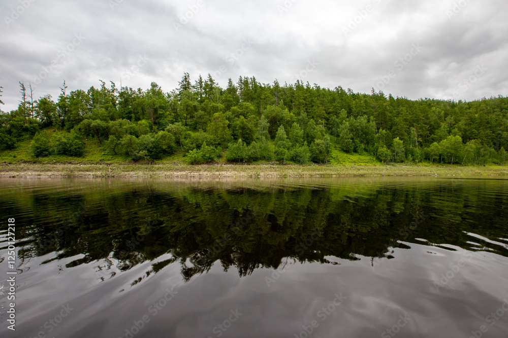 Fototapeta premium Picturesque lake. Green hills are reflected in the calm water of the Zeya reservoir. Protected Russia.