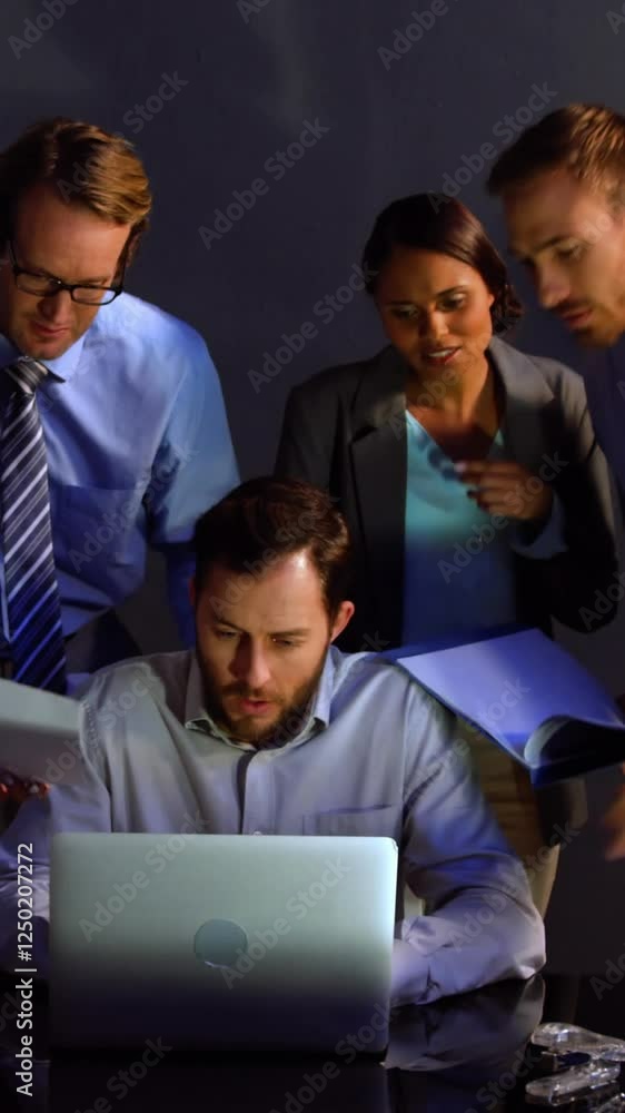 Businessman discussing over laptop and document with colleague in office Businessman discussing over laptop and document with colleague in office