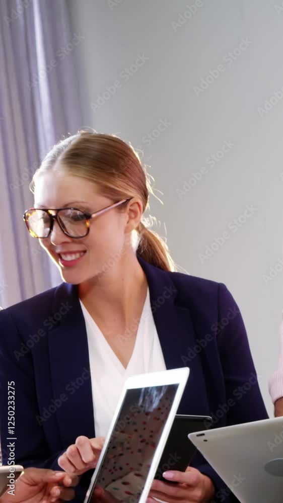 Businesspeople interacting over a laptop and digital tablet Businesspeople interacting over a laptop and digital tablet