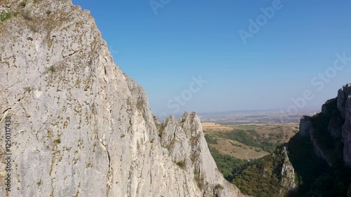 Flying through vertical limestone walls in a deep gorge, canyon, rock climbing aerial 