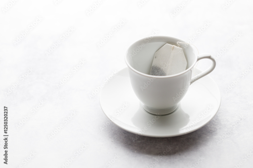 Cup of hot tea with tea bag on white table background. Cup of hot tea with tea bag on white table background.