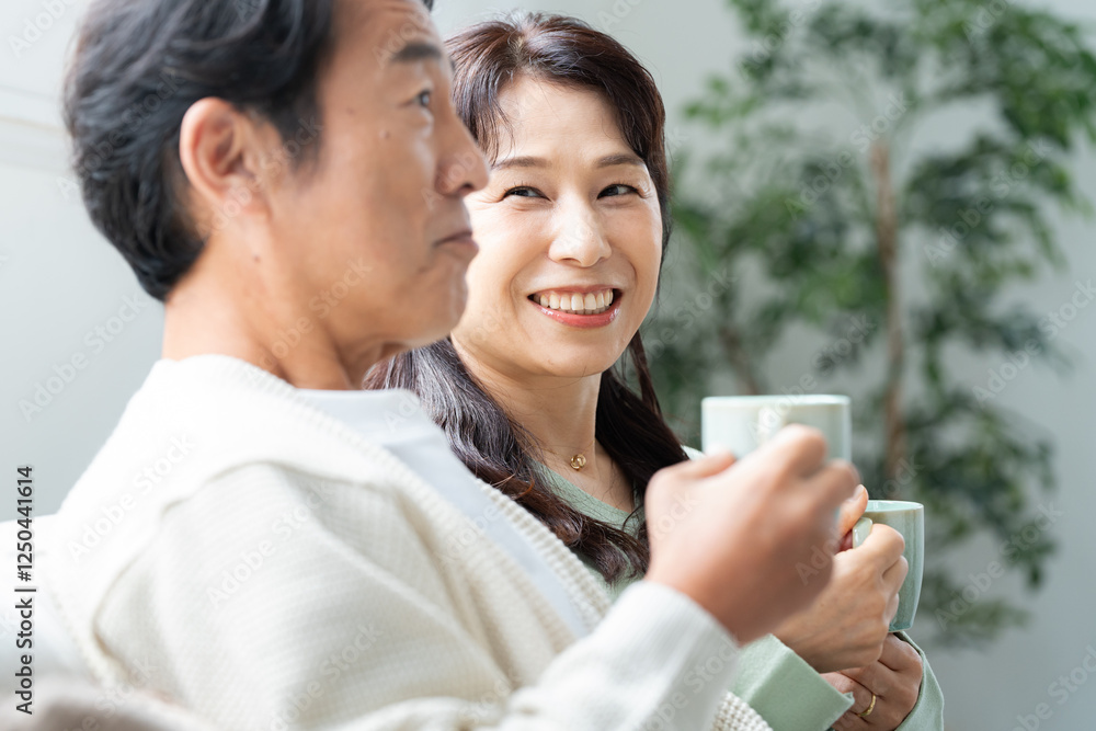 リビングでティータイムする50代夫婦