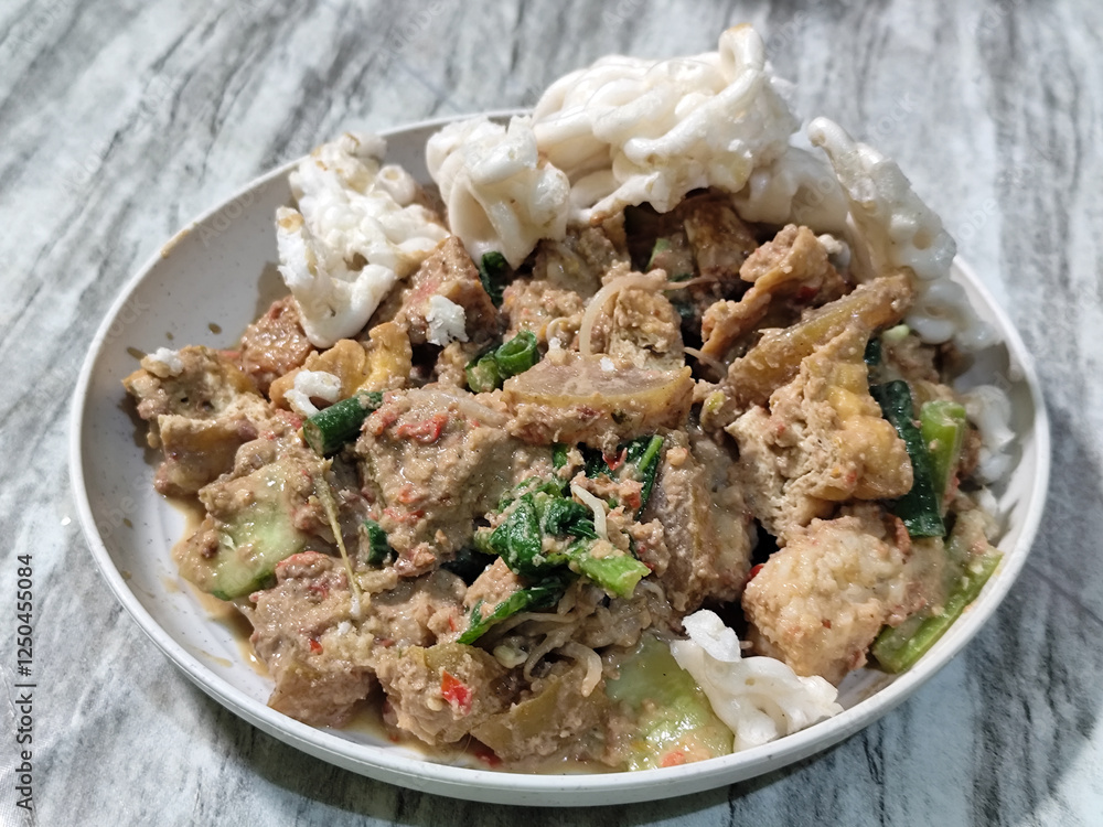 Rujak Cingur. Traditional Javanese food consisting of lontong with vegetables, peanut sauce, petis, tempeh, tofu, beef tongue, and crackers. Rujak Cingur. Traditional Javanese food consisting of lontong with vegetables, peanut sauce, petis, tempeh, tofu, beef tongue, and crackers.