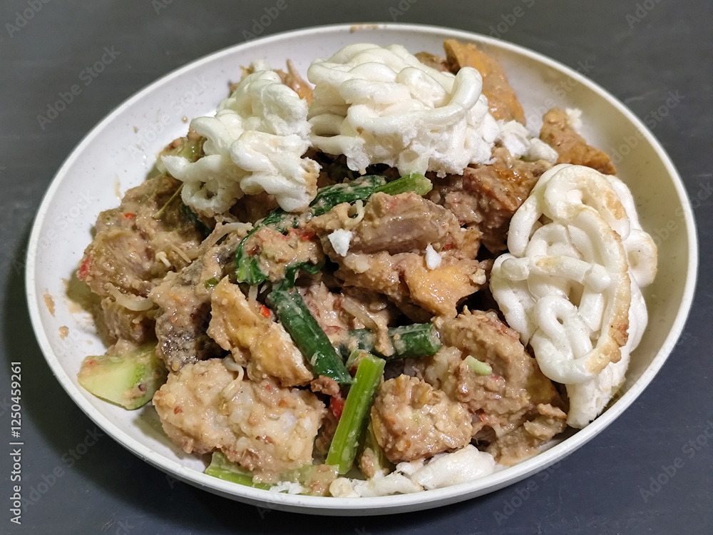 Rujak Cingur. Traditional Javanese food consisting of lontong with vegetables, peanut sauce, petis, tempeh, tofu, beef tongue, and crackers. Rujak Cingur. Traditional Javanese food consisting of lontong with vegetables, peanut sauce, petis, tempeh, tofu, beef tongue, and crackers.