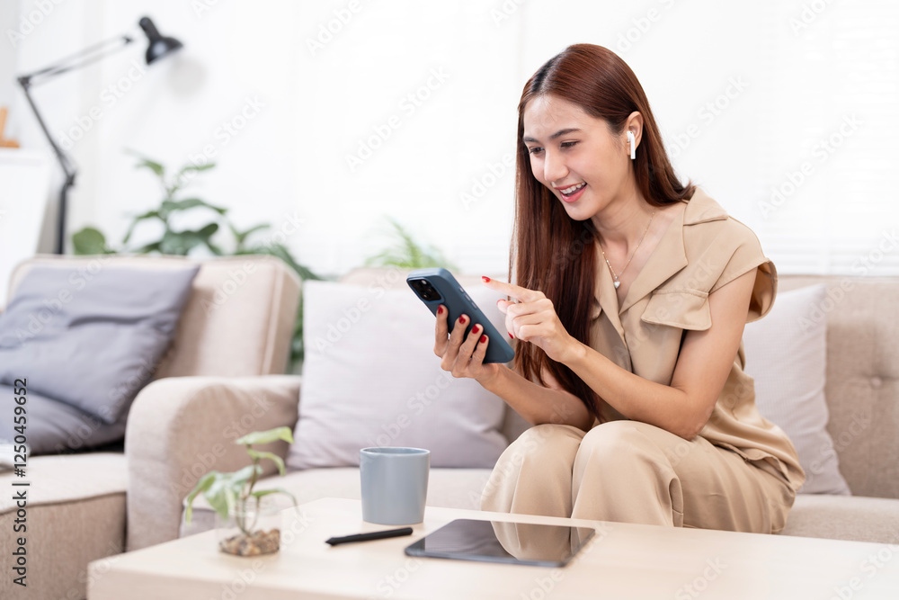 Smiling relaxed young woman sitting on couch at home, using cell phone technology Smiling relaxed young woman sitting on couch at home, using cell phone technology