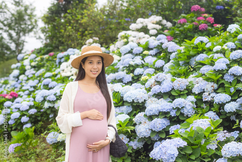 Expecting mother enjoys peaceful nature and flowers