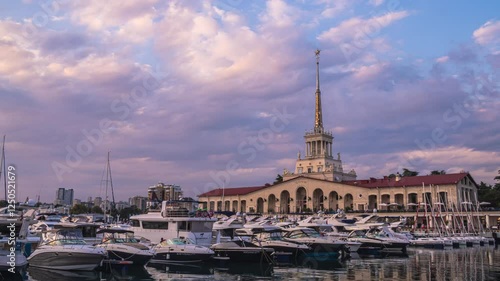 Time lapse of Sochi sea port. Turn on illumination in evenint time. Reflection of port in sea water. yachts and boats move in water. photo