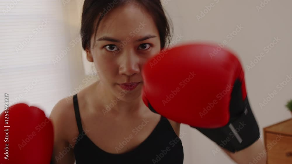 Unstoppable Force: A determined female boxer, her gaze unwavering, throws a powerful punch with red boxing gloves, demonstrating raw strength and focus. Unstoppable Force: A determined female boxer, her gaze unwavering, throws a powerful punch with red boxing gloves, demonstrating raw strength and focus.