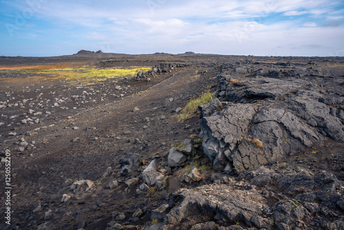 Scenic view of Valahnúkamöl Bay with dramatic cliffs, lava rocks, and the Atlantic waves in Iceland photo