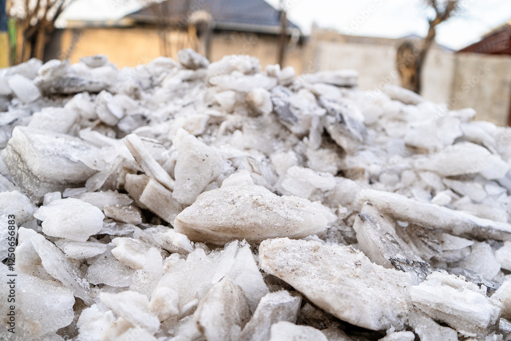 A close-up of shattered ice pieces piled together, showing textures and a mixture of translucent and opaque formations. The frozen chunks vary in size and shape, with sharp edges, smooth surfaces A close-up of shattered ice pieces piled together, showing textures and a mixture of translucent and opaque formations. The frozen chunks vary in size and shape, with sharp edges, smooth surfaces