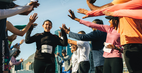 Fotografía Happy female runner celebrates as crowd cheers during outdoor marathon