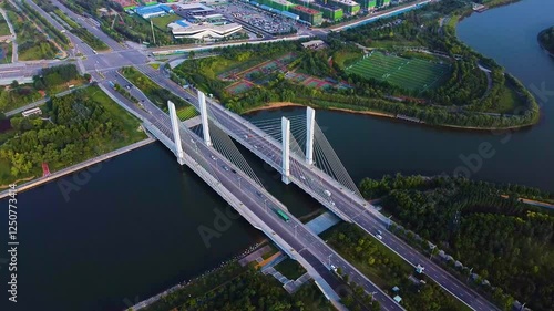 Stunning aerial view of Zhengzhou Beilonghu Canal Bridge illuminated at dusk with surrounding landscape photo